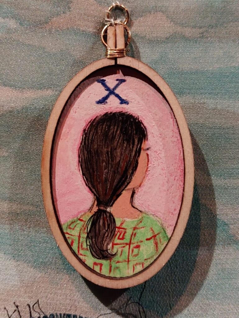 A cameo stitched to The Map with the back of a young girls head, representing the girl in the X case