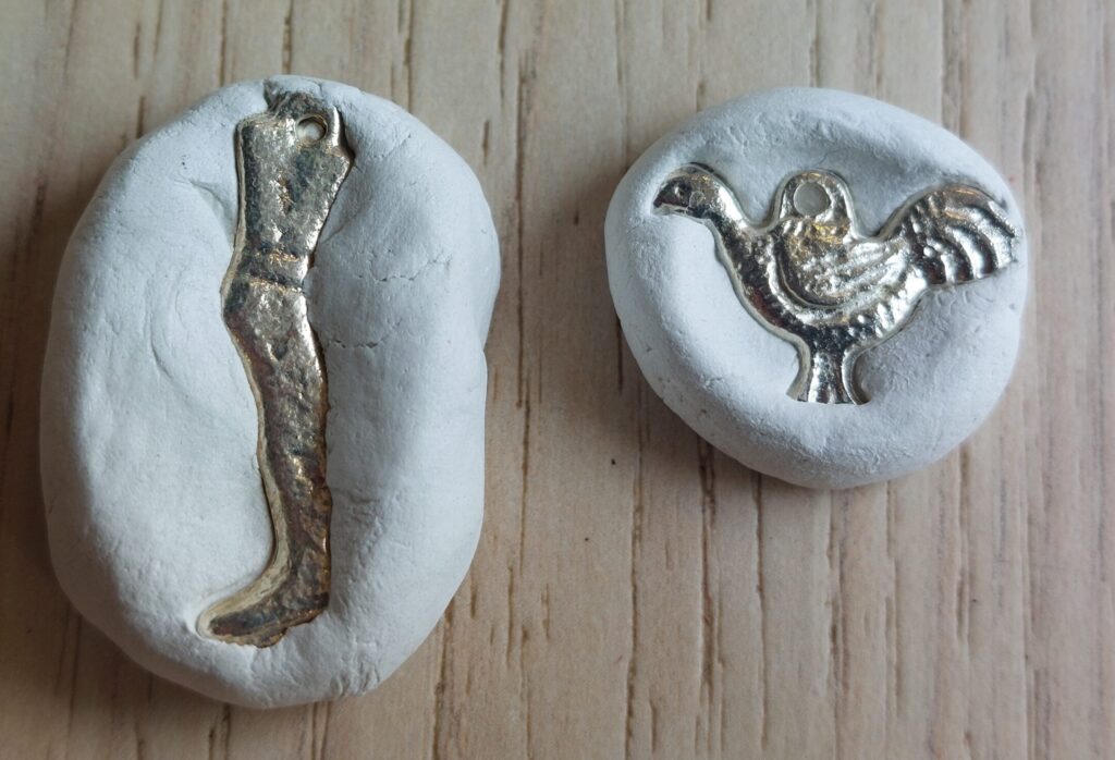 Two metal shapes encased in plaster. One is the shape of a leg, the other a bird. from The Tower by Jesse Jones