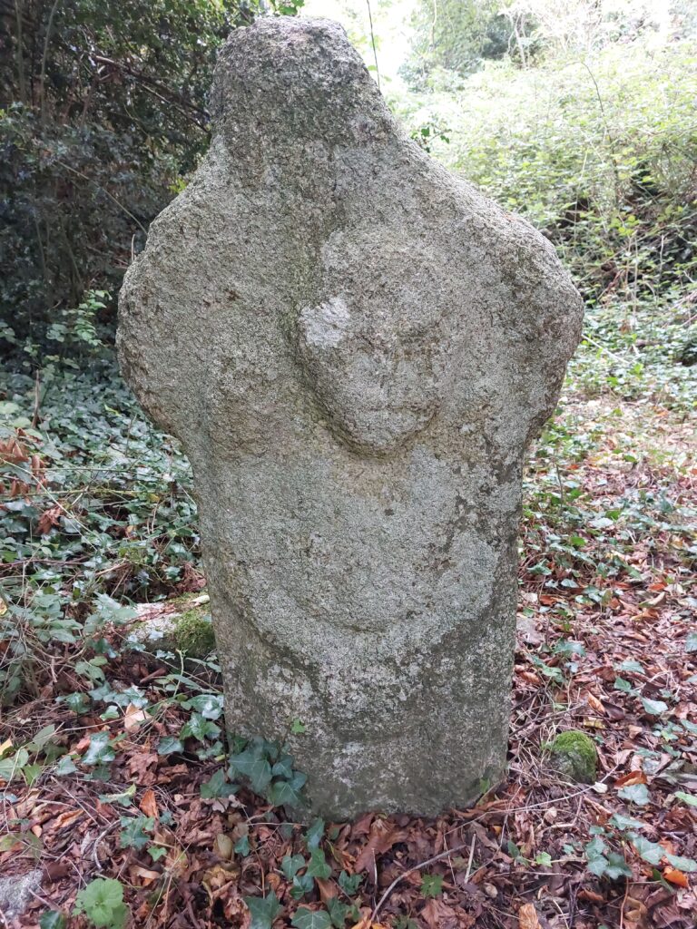 A stone engraving on a cross-shaped marker thought to be a Sheela na Gig but likely a more recent addition at Stepaside Golf Course, Dublin