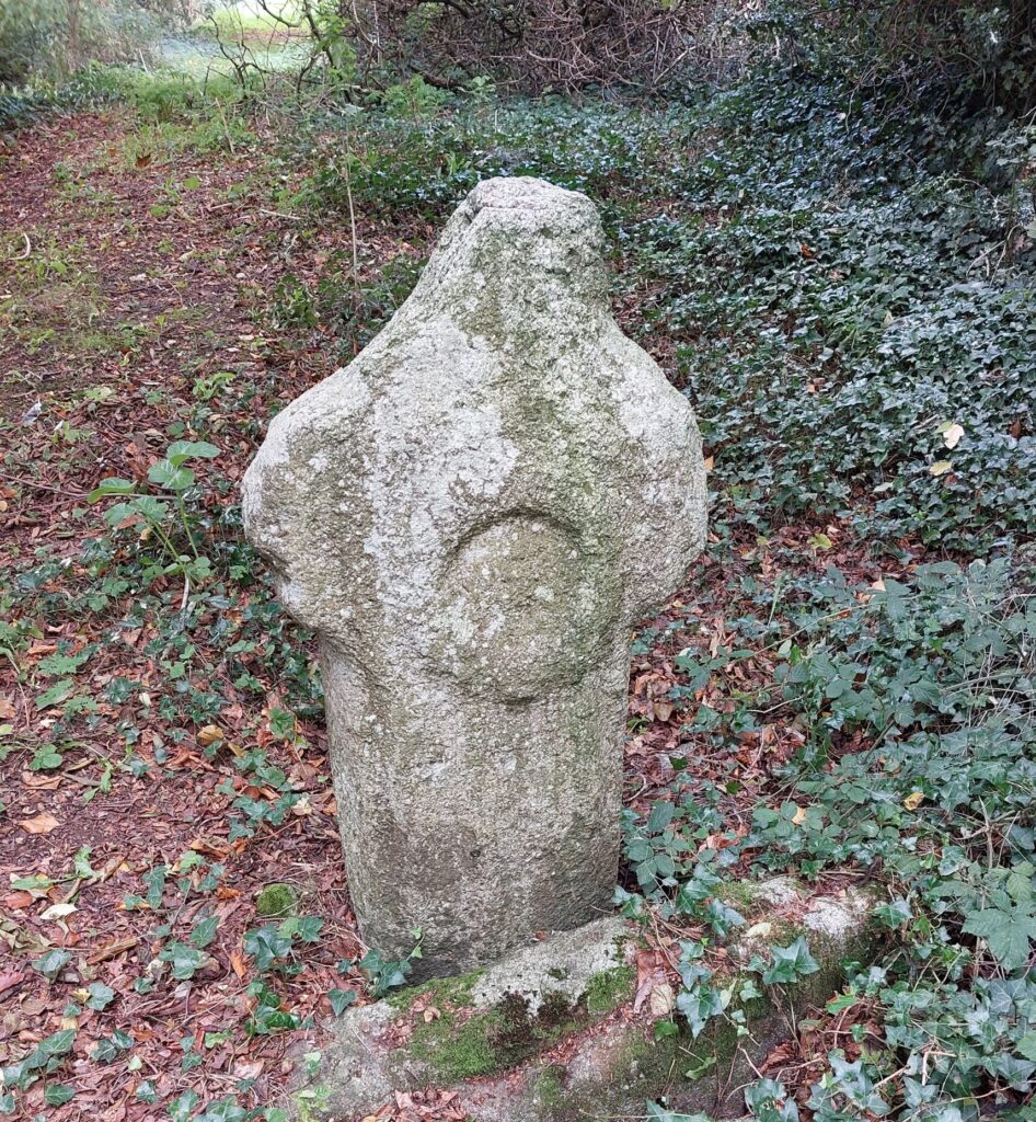 A stone carving of a circle on a cross-shaped grave marker at Stepaside Golf Course, Dublin