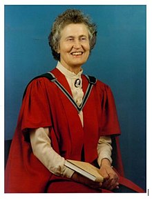 Portrait of Professor Ethna Gaffney wearing a red robe and ceremonial chain