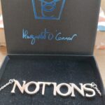 Silver neckchain with the word Notions, designed by Margaret O'Connor