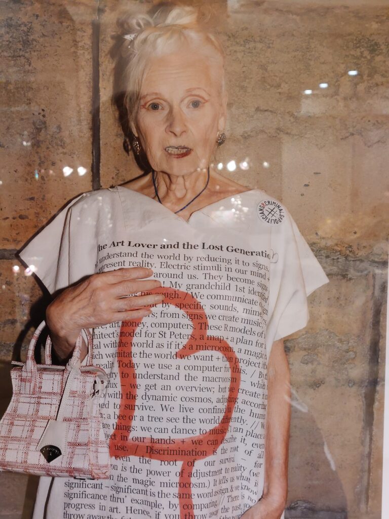 Poster of punk designer Vivienne Westwood wearing a statement t-short covered with very small text