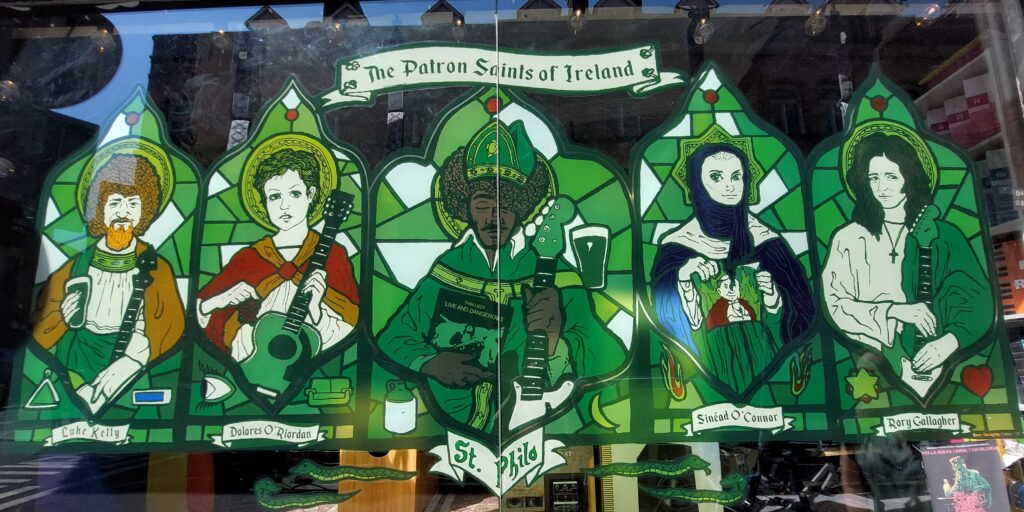 A pub window featuring the Patron Saints of Ireland - musicians Rory Gallagher, Luke Kelly, Sinead O'Connor, Dolores O'Riordan and Phil Lynott in the style of a stained glass window
