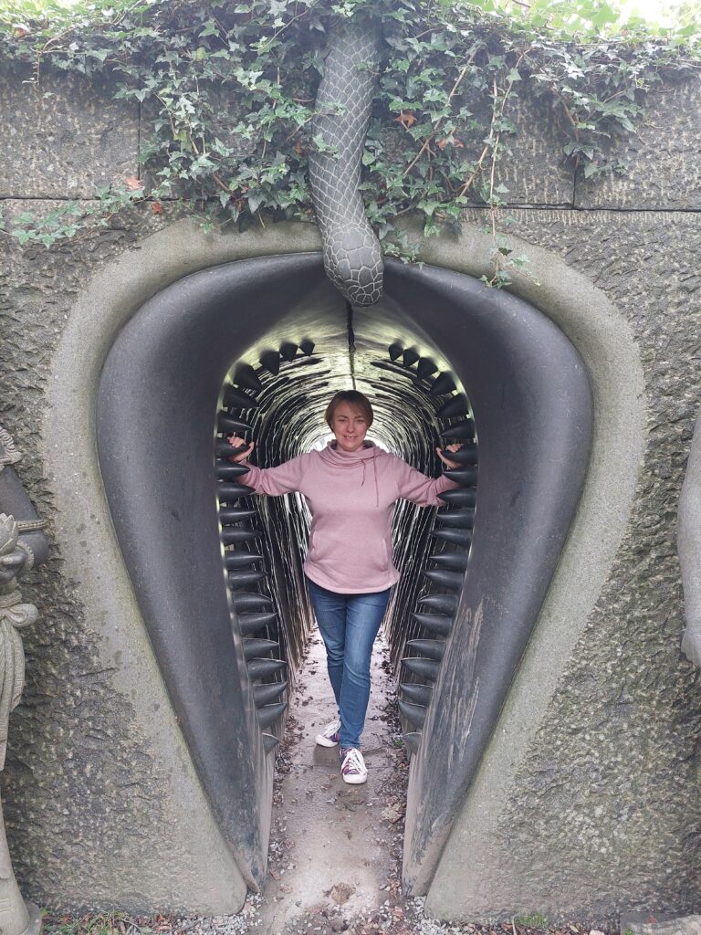 A woman stands inside a sculpture of a vagina with teeth