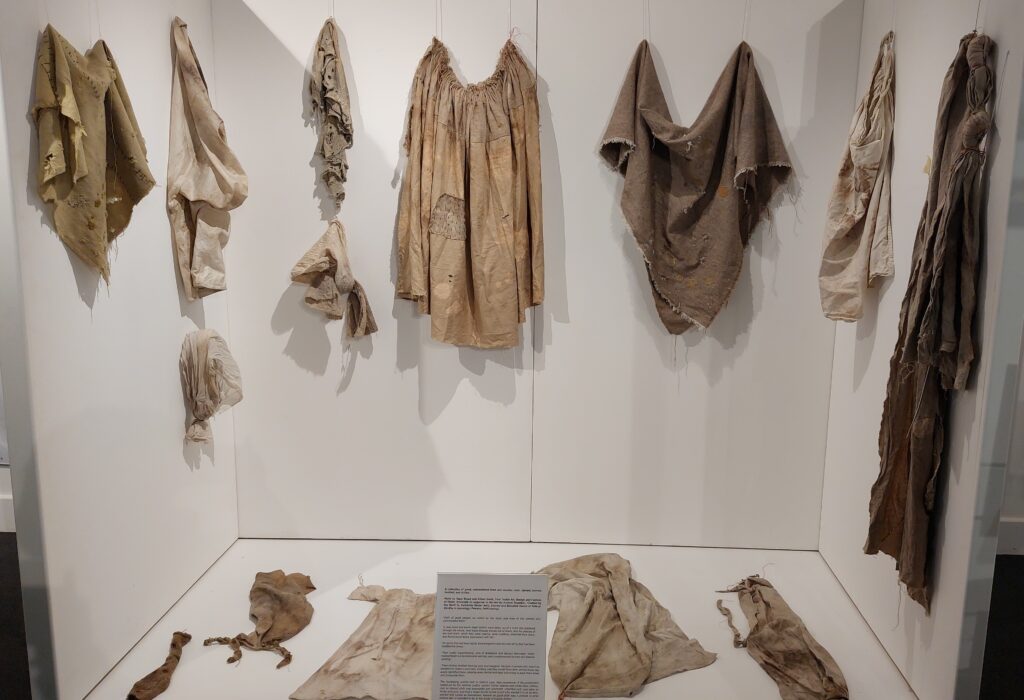 Art installation at Islandmagee exhibition featuring tattered clothings from the period