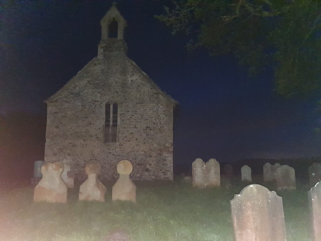 Old church and graveyard at night.